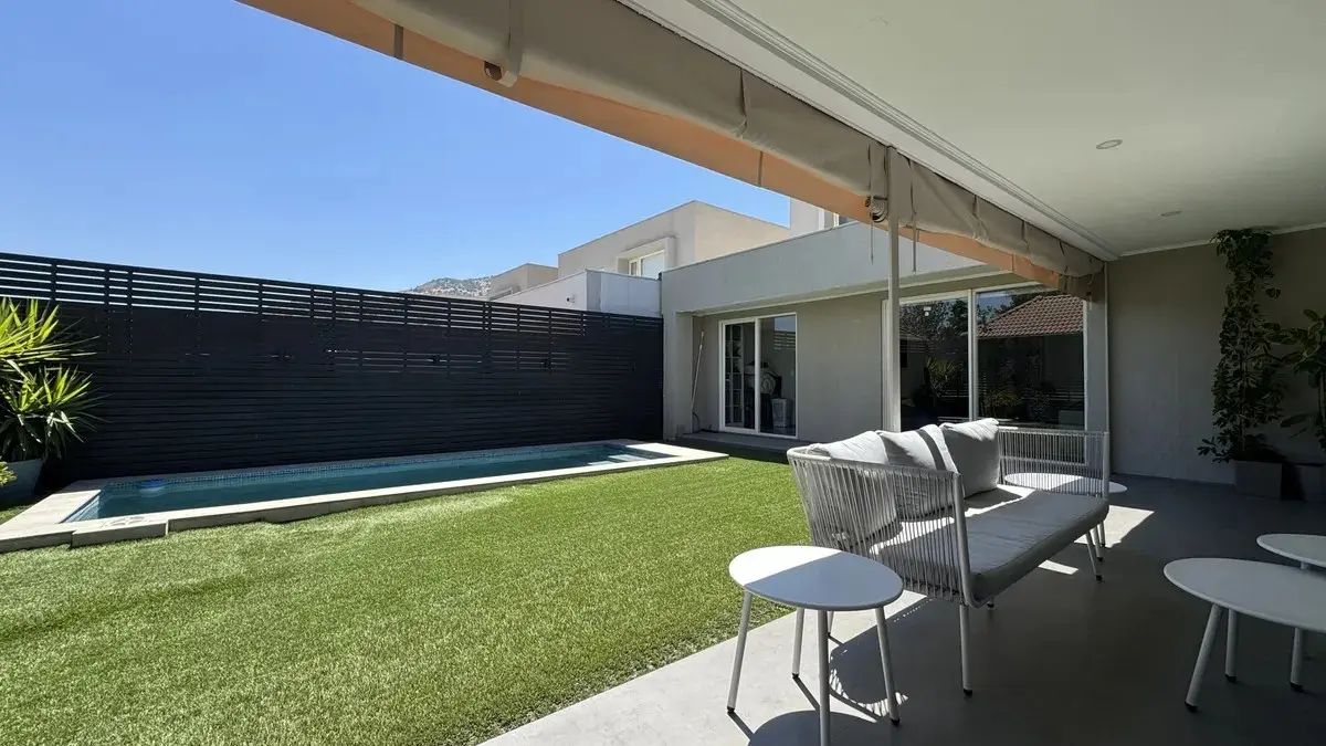 Vista de patio, desde quincho hacia casa y piscina.